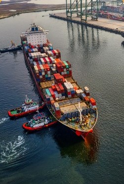 Buque de carga con remolcadores en puerto